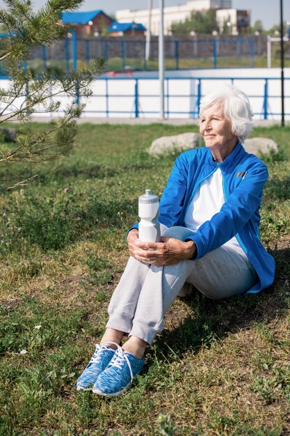 Moderne senior vrouw rustend op gazon