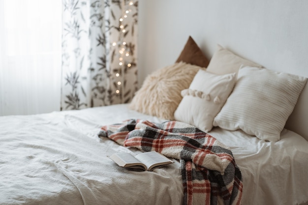 Foto moderne slaapkamer met kussens op bed en open boek.