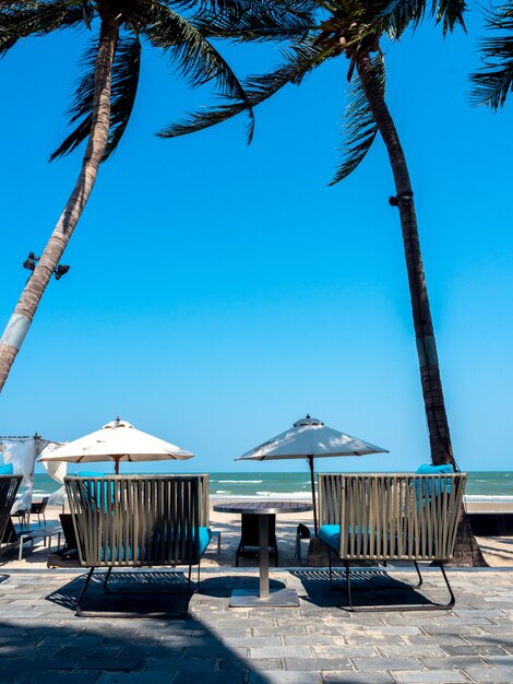 Moderne stoelen met bijzettafel op balkon met uitzicht op zee