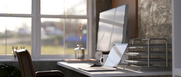 Moderne thuiskantoorstudio in de buurt van raam met pc-computer op tafel tegen de stenen muur