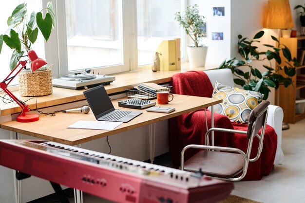 Moderne tienerkamer met laptop en synthesizer op tafel voor muzikale les