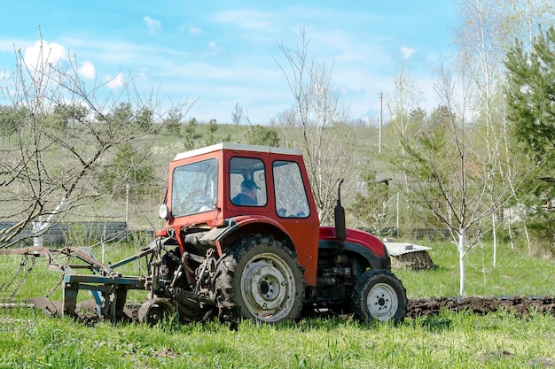 Moderne tractormachines die landbouwgebiedweide ploegen bij landbouwbedrijf bij de lenteherfst Landbouwer die grondbewerking cultiveert en maakt alvorens planten en gewassen te zaaien natuur platteland landelijke scène