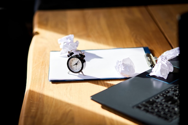 Foto moderne werkplek, houten bureau in hardlight, zonlicht met klok, vel papier