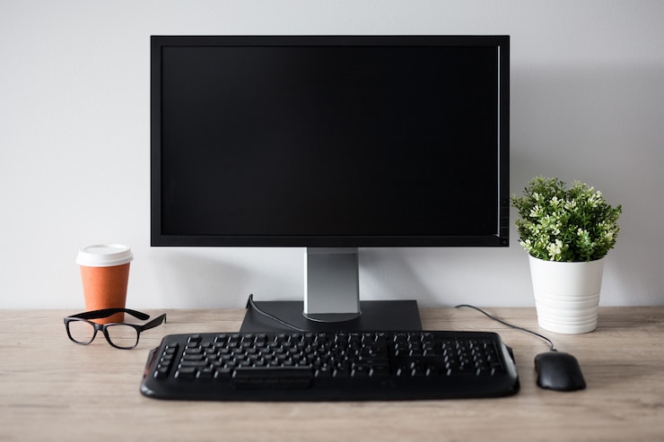 Foto moderne werkplek met blanco scherm pc, bloempot, glazen en kopje koffie