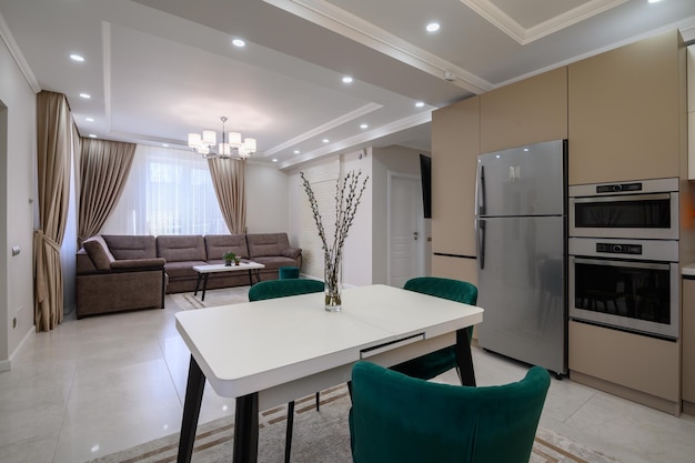 Moderne witte en beige grote luxe keuken en eettafel in studio appartement