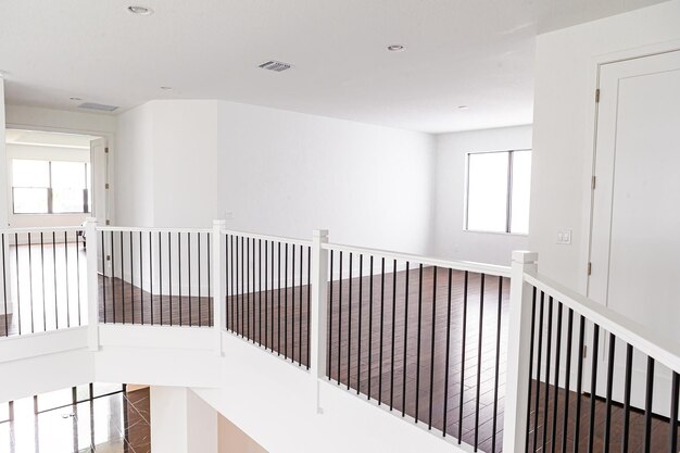 Moderne witte houten trap in het interieur van een nieuw huis met grote ramen