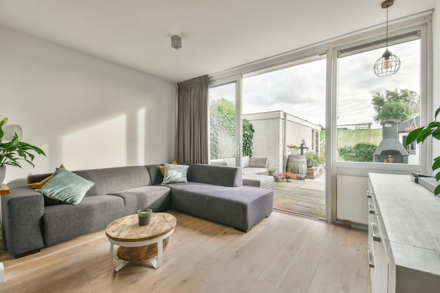 Moderne woonkamer met een comfortabele grijze bank en natuurlijk licht
