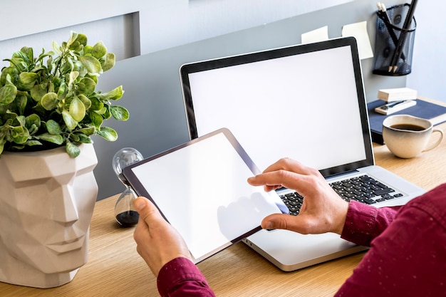 Moderne zakelijke compositie op het thuiskantoor met freelancer, mock-up tabletscherm, plant, notities, mobiele telefoon en kantoorbenodigdheden in stijlvol concept van huisdecor.