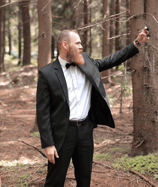 Foto moderne zakenman die een selfie neemt in een dennenbos
