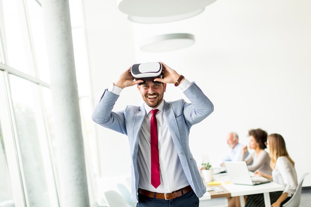 Moderne zakenman met virtuele werkelijkheidshoofdtelefoons in het bureau