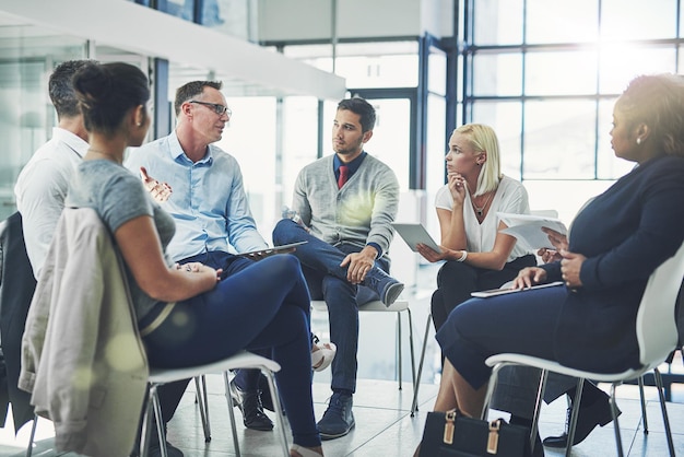 Moderne zakenmensen in een informele teambuildingdiscussie of zakelijke praatsessie Teamleidermanager of supervisor die met een groep werknemers of collega's praat over nieuw workflowbeheer