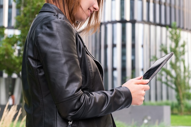 Moderne zakenvrouw die online praat met een tablet in de buurt van het zakencentrum