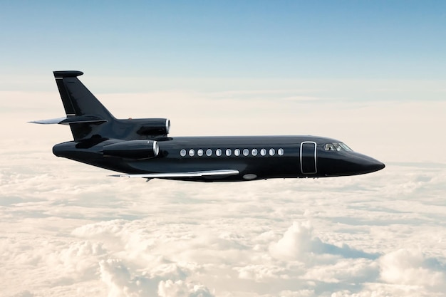 Moderne zwarte luxe executive business jet vliegt in de lucht boven de wolken