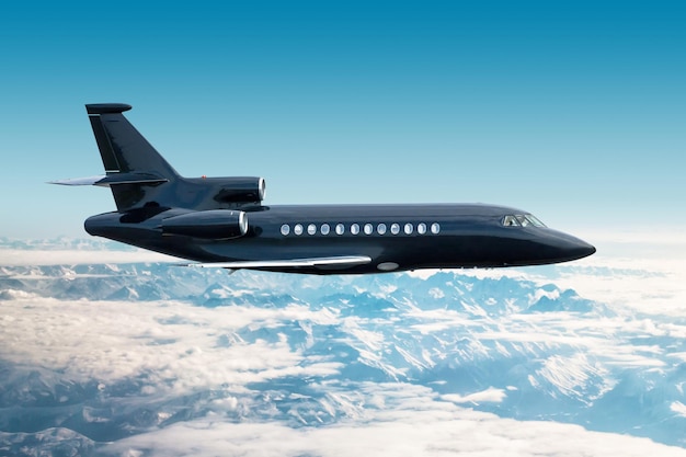 Moderne zwarte luxe privéjet vliegt over besneeuwde bergen