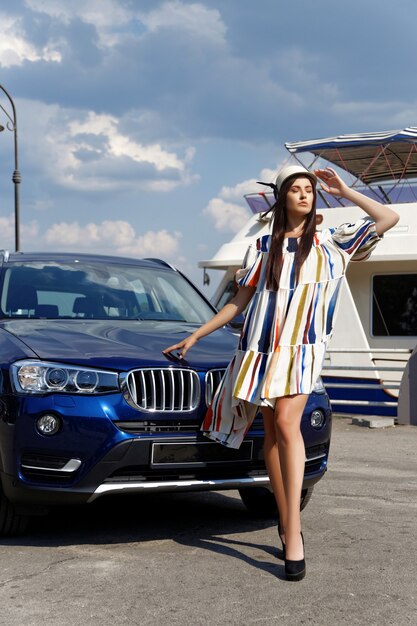 Modieus brunette meisje in de buurt van de auto