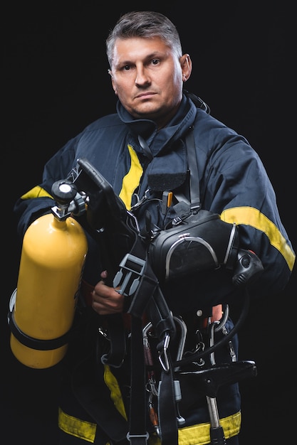 Modieus portret van een man in branduitrusting op een zwarte studioachtergrond