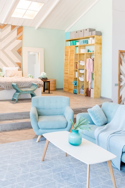 Modieus ruim appartement met een stijlvol design in groene, grijze en witte pastelkleuren met groot raam en decoratieve wanden. slaapkamer en keukenruimte