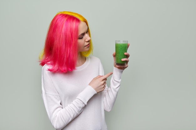 Modieus tienermeisje met glas verse groene smoothies