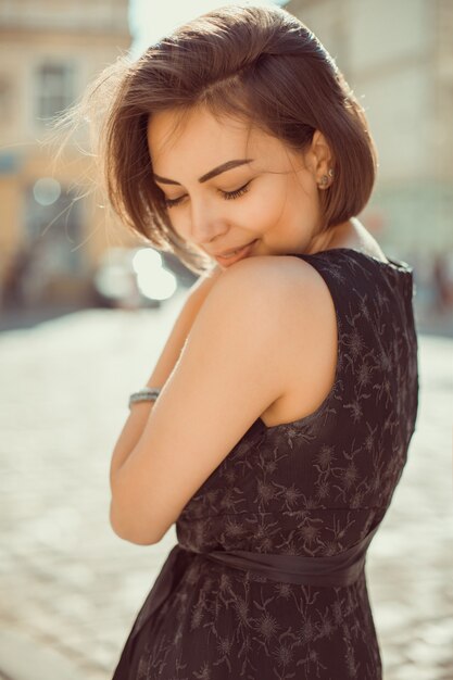 Modieus vrolijk model met trendy outfit, wandelend door de straten van de stad