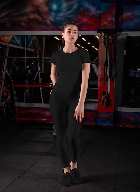 Modieus zwart compressie ondergoed sjabloon op slank meisje poseren in de sportschool voor ontwerppatroon