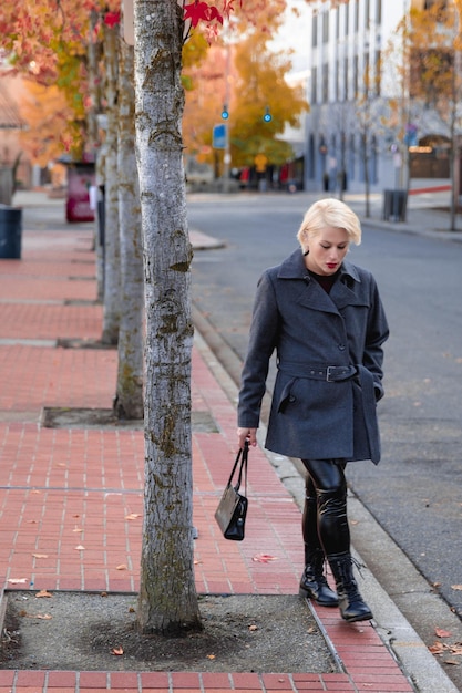 Modieuze blonde vrouw die de stad verkent