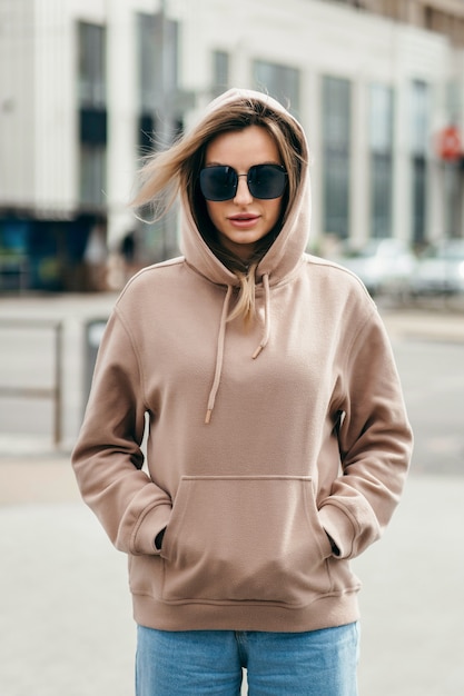 Modieuze blonde vrouw in bruine oversized hoodie