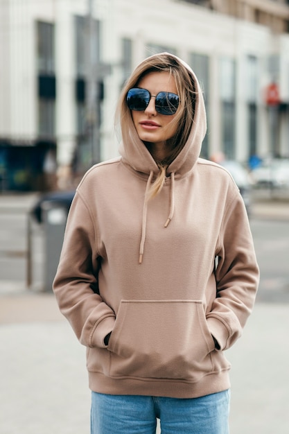 Foto modieuze blonde vrouw in bruine oversized hoodie