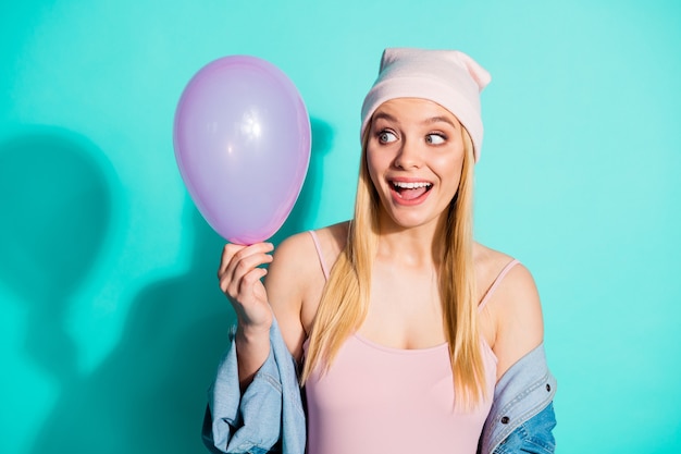 Modieuze blonde vrouw poseren tegen de blauwe muur