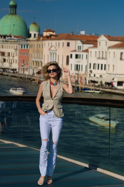 Modieuze jonge vrouw in stijlvolle mode-look wandelen in venetië italië vrouw toerist in venetië summ