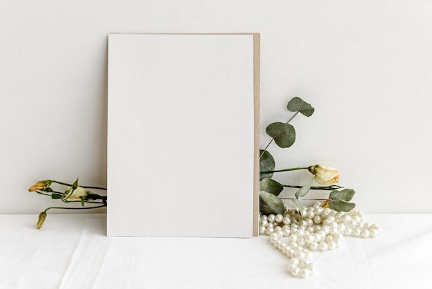 Modieuze voorraad briefpapier achtergrond witte kaart voor belettering en droge planten en bloemen op een witte tafel Bruiloft vrouwelijke achtergrond leeg voor een uitnodigingskaart