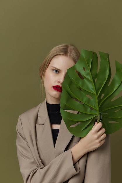 Modieuze vrouw groene palmblad jas lichte make-up Lifestyle poseren