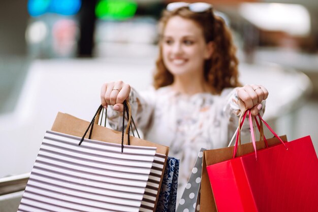 Modieuze vrouw met veelkleurige tassen in winkelcentrum The joy of consumptie