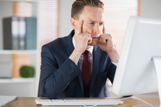 Modieuze zakenman die bij zijn bureau werkt