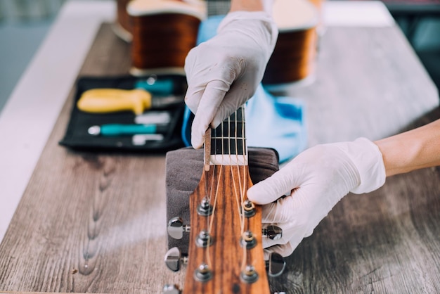 Modify acoustic guitar Guitar repairman is working Closeup