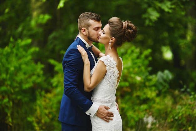 Modish groom kissing gorgeous bride during the wedding ceremony a loving couple a girl