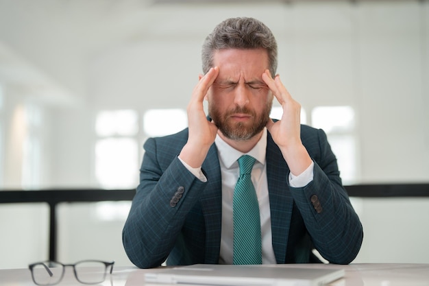 Foto moe, hoofdpijn en vermoeide ogen door laptop. zakenman met stress, burn-out en vermoeidheid van de ogen. zakenman wrijven vermoeide ogen na computerwerk.