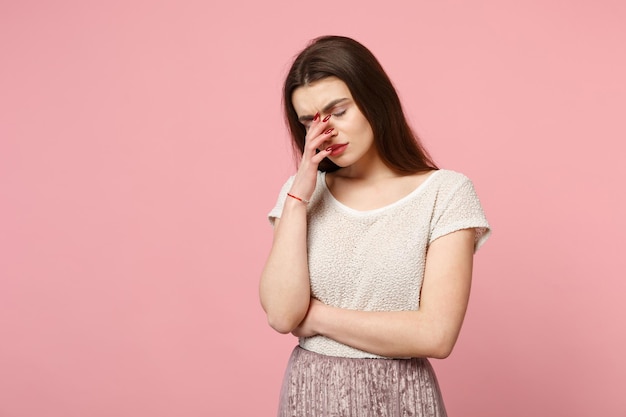 Moe jonge vrouw in casual lichte kleding poseren geïsoleerd op roze achtergrond, studio portret. Mensen oprechte emoties levensstijl concept. Bespotten kopie ruimte. Ogen gesloten houden, hnd op het gezicht zetten.