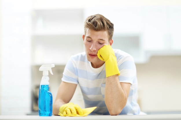 Moe knappe man rusten na het schoonmaken van de keuken