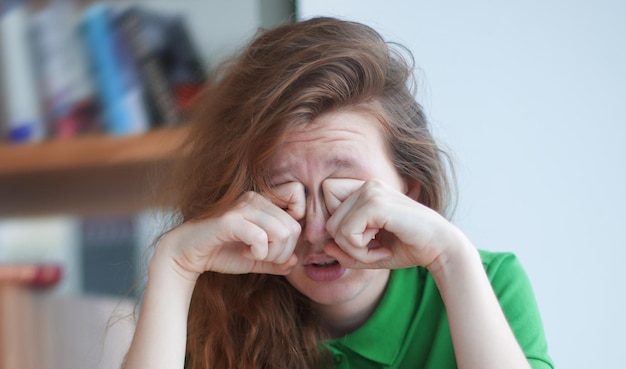 Foto moe, overwerkte meid, uitgeputte jonge vrouw met een bril, hogeschool of universiteitsstudent studeert hard