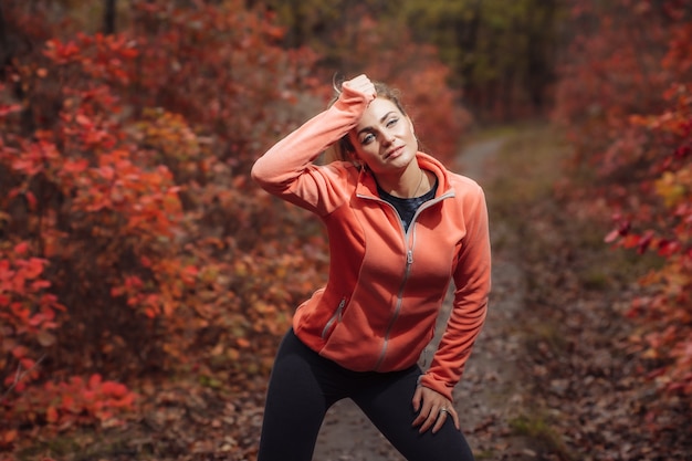 Moe sport vrouw in sportkleding in de herfst bos