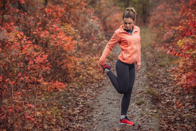 Moe sport vrouw in sportkleding in de herfst bos