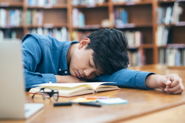 Moe uitgeput student slapen in de bibliotheek