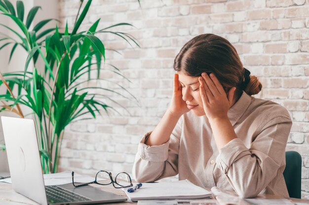 Moe verveelde tienermeisje schoolstudent gevoel hoofdpijn of vermoeidheid huiswerk thuis Uitgeput depressief zieke tiener alleen studeren bezorgd over moeilijke onderwijsproblemen conceptxA