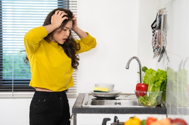 Foto moe vrouw afwassen in de gootsteen in de keuken thuis