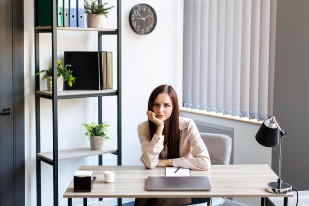 Moe zakenvrouw zittend op haar werkplek Overwerk overuren en stress op het werk concept