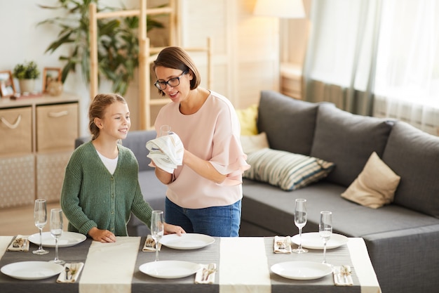 Moeder afvegend servies met dochter