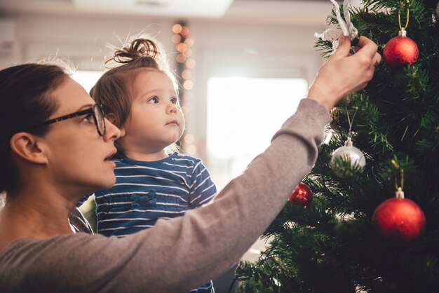 Moeder bedrijf dochter en kerstboom versieren