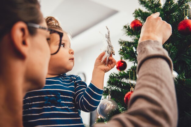 Moeder bedrijf dochter en kerstboom versieren