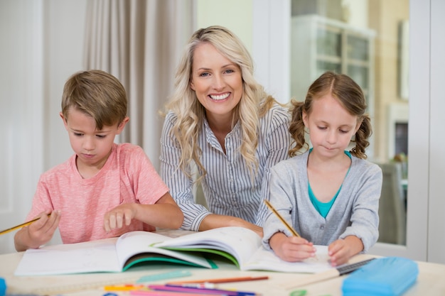 Moeder bijwonende kinderen die huiswerk doen