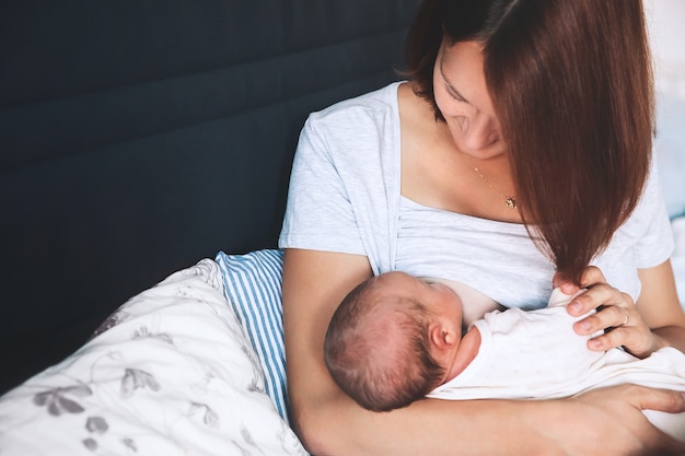 Moeder borstvoeding baby in haar armen thuis mooie moeder borstvoeding haar pasgeboren kind